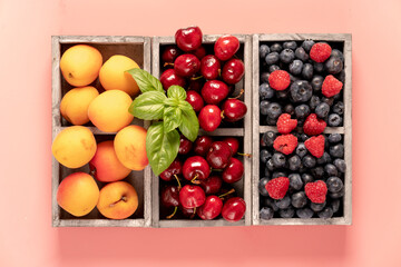 blueberries, cherries and peaches in a wooden box.