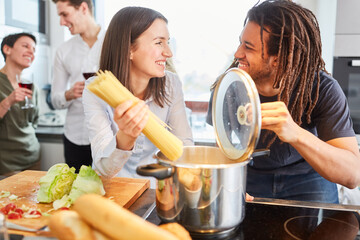 Freunde kochen zusammen Spaghetti Nudeln in Küche für Mittagessen