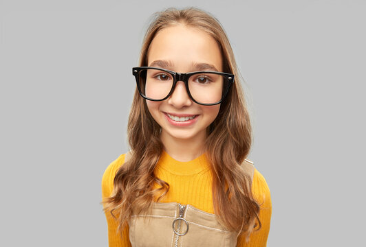 high school, education and vision concept - smiling teenage student girl in glasses over grey background