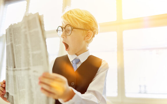 Amazed child reads surprise in newspaper