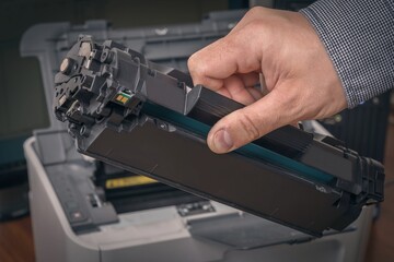Man is replacing black cartridge in a printer