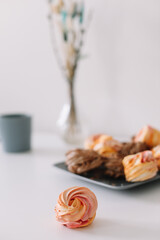 Cup of coffee with marshmallows and flowers on the table. Romantic morning. Tasty breakfast. Flat lay, top view, copy space.