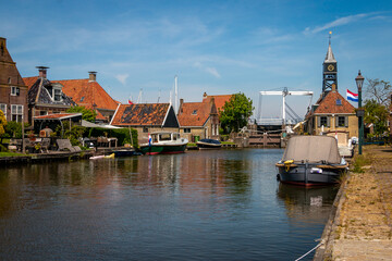 Naklejka premium Hindeloopen a beautiful town in the Netherlands on the IJsselmeer, province of Friesland with canal boats and a harbor