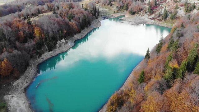 Green lake, mtsvanetba with sky reflection on water in autumn. Adjara, Georgia. Aerial view. Drone footage. 