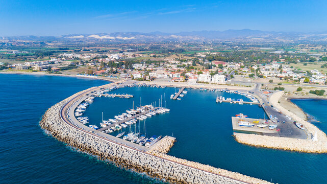 Aerial Bird's Eye View Of Zygi Fishing Village Port, Larnaca, Cyprus. The Fish Boats Moored In The Harbour With Docked Yachts And Skyline Of The Town Near Limassol From Above.