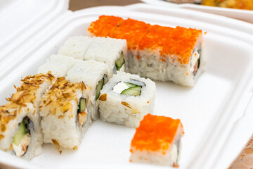 sushi and rolls with home delivery, eat at the table against the background of food
