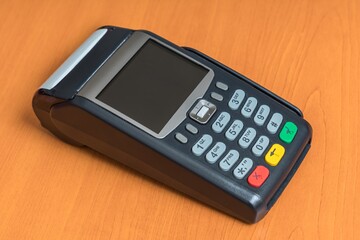 Payment terminal isolated on wooden table background