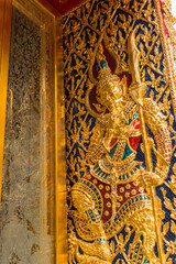 The guardian's stucco with the Chinese face, with a beard, wearing a costume like Chinese and Thai warrior on the door of  Wat Ratchabophit, Bangkok, Thailand.