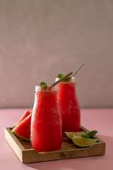 Non-alcoholic cocktail. Freshly squeezed juice from a watermelon on a table. Healthy eating and fruitarianism. Vertical orientation with copy space