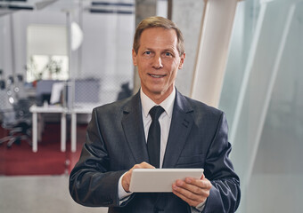 Cheerful man holding tablet in both hands