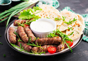 Pork kebab with pita bread with green onions.