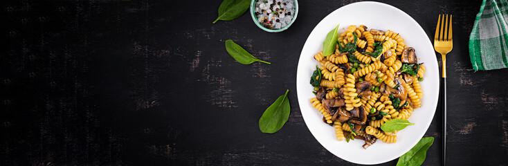 Fusilli pasta with spinach and mushrooms on a white plate. Vegetarian / vegan  food. Italian...