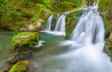 Waterfall with rocks and green moss near Gunzesried. Allgäu, Bavaria, Germany
