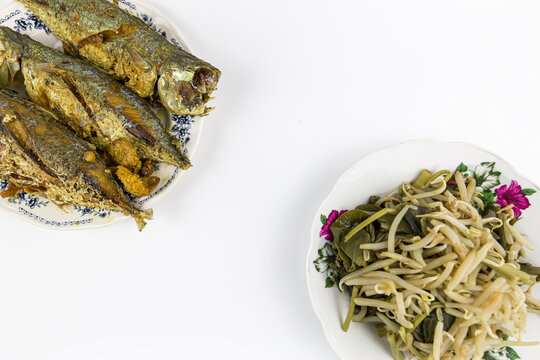 Ikan kembung goreng or fried long jawed mackerel with Homemade of tradisional dish called pecal , variety of fresh vegetables isolated on white background