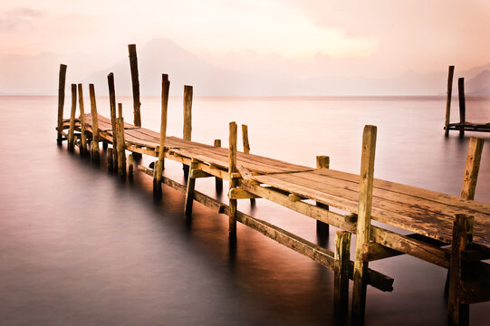 Pier on Lake Atitlan at sunset with volcano in the background