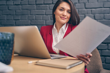 Pleased brunette woman working in the office