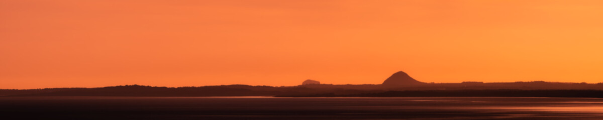 Naklejka na ściany i meble gorgeous sunrise landscape minimalist panorama sightseeing of Edinburgh and ocean from Arthur's Seat