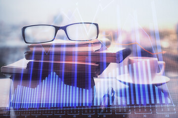 Financial graph hologram with glasses on the table background. Concept of business. Double exposure.