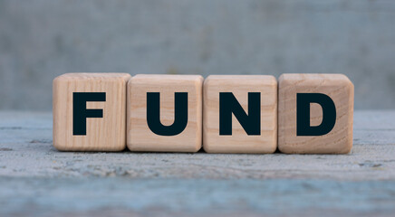 FUND word on cubes on an old gray background .