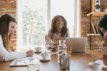 Young business woman in modern office with team. Creative meeting, tasks giving. Smiling,...