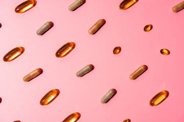 Top view of pills on pink pink background with harsh shadows. Trendy flatlay of preventive medicine