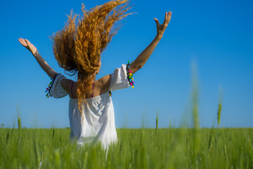 Summer holidays vacation of carefree beautiful long haired woman runs on summer sunny field....