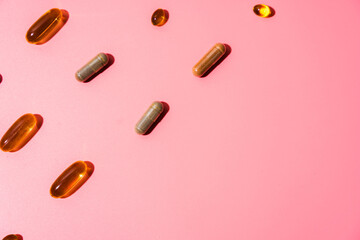 Top view of pills on pink pink background with harsh shadows. Trendy flatlay of preventive medicine