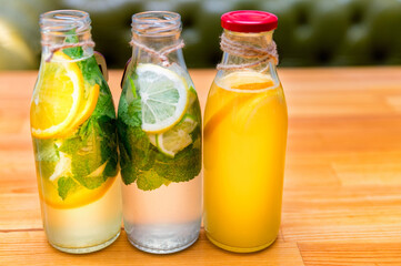 Set of bottles with lemonade or mojito cocktail with lemon and mint