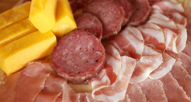 chopping board with mixed cold cuts salami cooked on the grill a