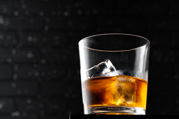 Whisky glass against dark black grunge wall