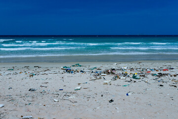 Plastic bottles and other rubbish thrown on the sandy seashore, trash on the sea beach. ecological problem.  Dirty