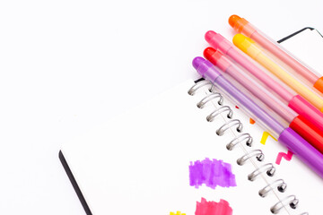 markers of various colours on a notebook