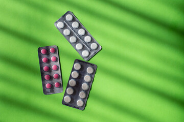 Blisters of pills on a green background. Theme of medicine.
