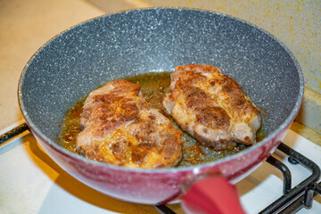 Juicy appetizing steaks  from fat pork fried in a pan with olive oil