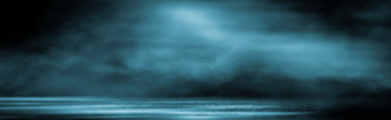 Dark dramatic abstract scene background. Neon glow reflected on the pavement. Smoke, smog and fog. Dark street, wet asphalt, reflections of rays in the water. Abstract dark blue background. 