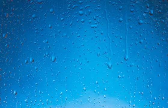 Blue water drops background. Blue water drops on a boat glass background