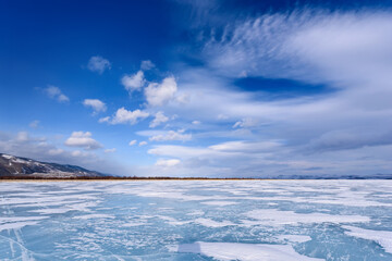 Frozen Lake Baikal. Beautiful stratus clouds over the ice surface on a frosty day.