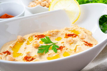 hummus paste with lemon and chilli on white background