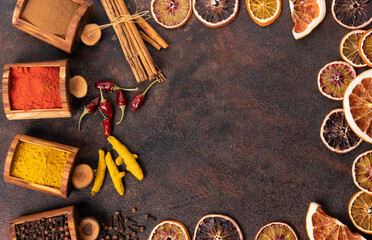 Various spices cinnamon, turmeric, pepper and anise, onions, coriander in wooden boxes on a black background.