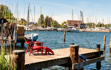 Lehnsessel auf einem Bootssteg, hinten Jachthafen, Stadt Arnis an der Schlei, Schleswig-Holstein, Deutschland
