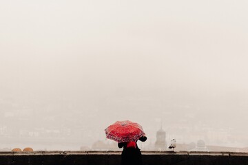 Woman with a red umbrella watching the views