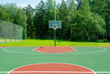 Empty sreet basketball court in the park on the sunny summer day.