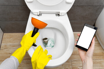 Overflowing broken toilet. clogged toilet. a smartphone with a white screen for advertising about...