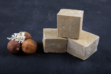 Natural handmade soap and bay leaves (laurel) on black wood background.