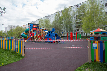 Playground in the courtyard of a residential building, children's steam locomotive, closed for quarantine