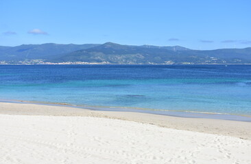 Bay with turquoise water and beach with white sand and blue sky. San Francisco beach, Muros, Galicia, Spain.