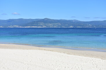 Bay with turquoise water and beach with white sand and blue sky. San Francisco beach, Muros, Galicia, Spain.