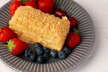 Piece of russian honey cake medovik served with berries