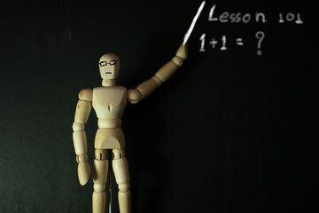 wooden mannequin pose playing soccer on a black background