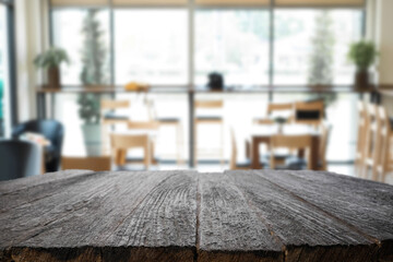 Empty wooden desk space platform over blurred restaurant or coffee shop background for product display montage.